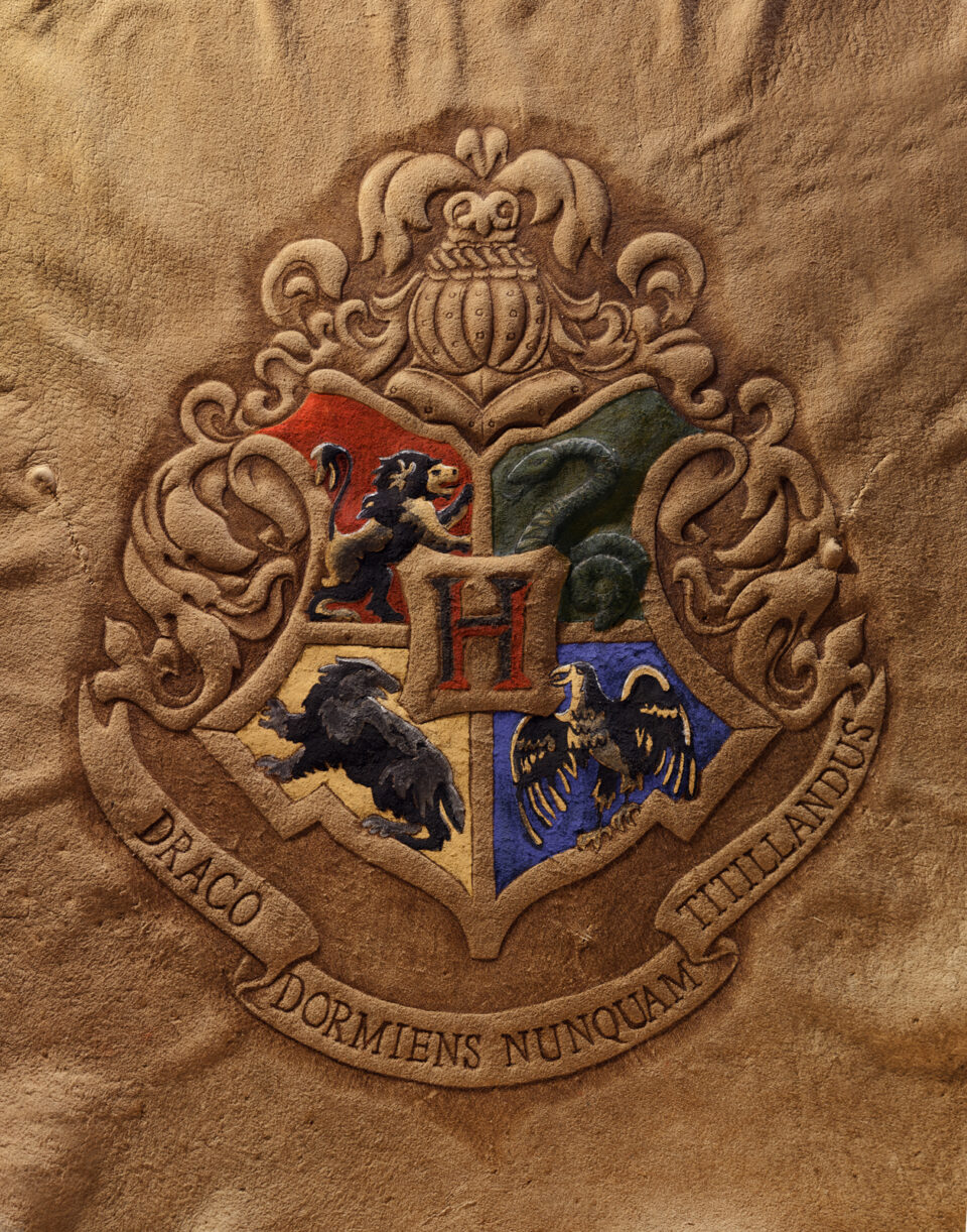 Photo of Cave Geek Art's Harry Potter Hogwarts Crest burned on buckskin leather and painted with primitive tools.